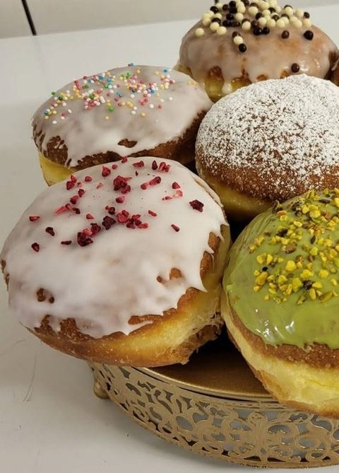 Pączki z lukrem, posypką, cukrem pudrem i polewą pistacjową