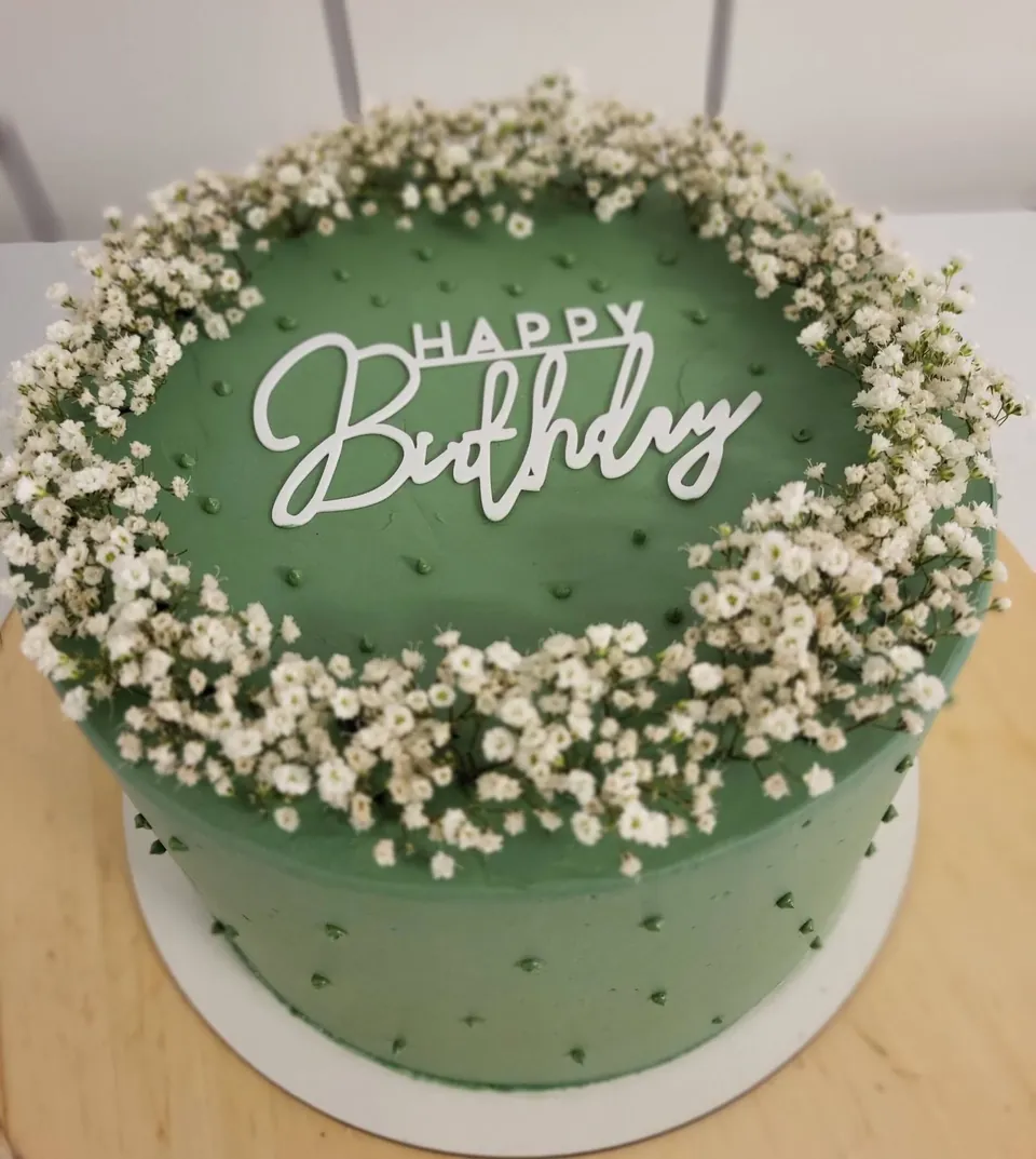 Zielony tort urodzinowy z wianuszkiem gipsówki i napisem Happy Birthday