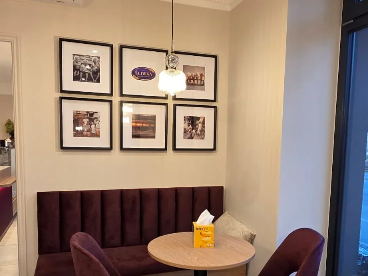 Ława, stolik i ramki ze starymi fotografiami w cukierni